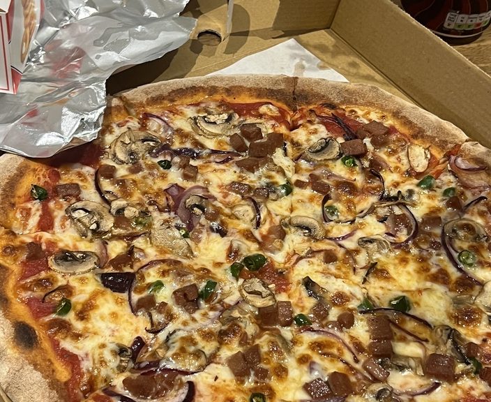 A mushroom, onion and pepperoni pizza in its box